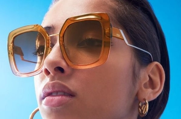 Mulher morena usando óculos de sol Fendi cor laranja