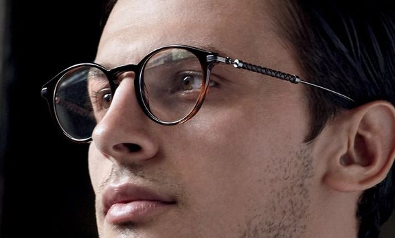 homem com cabelo castanho usando óculos de grau redondo com armação preta